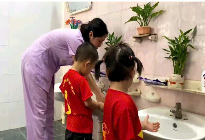 Trẻ rửa tay với sự hướng dẫn của cô giáo