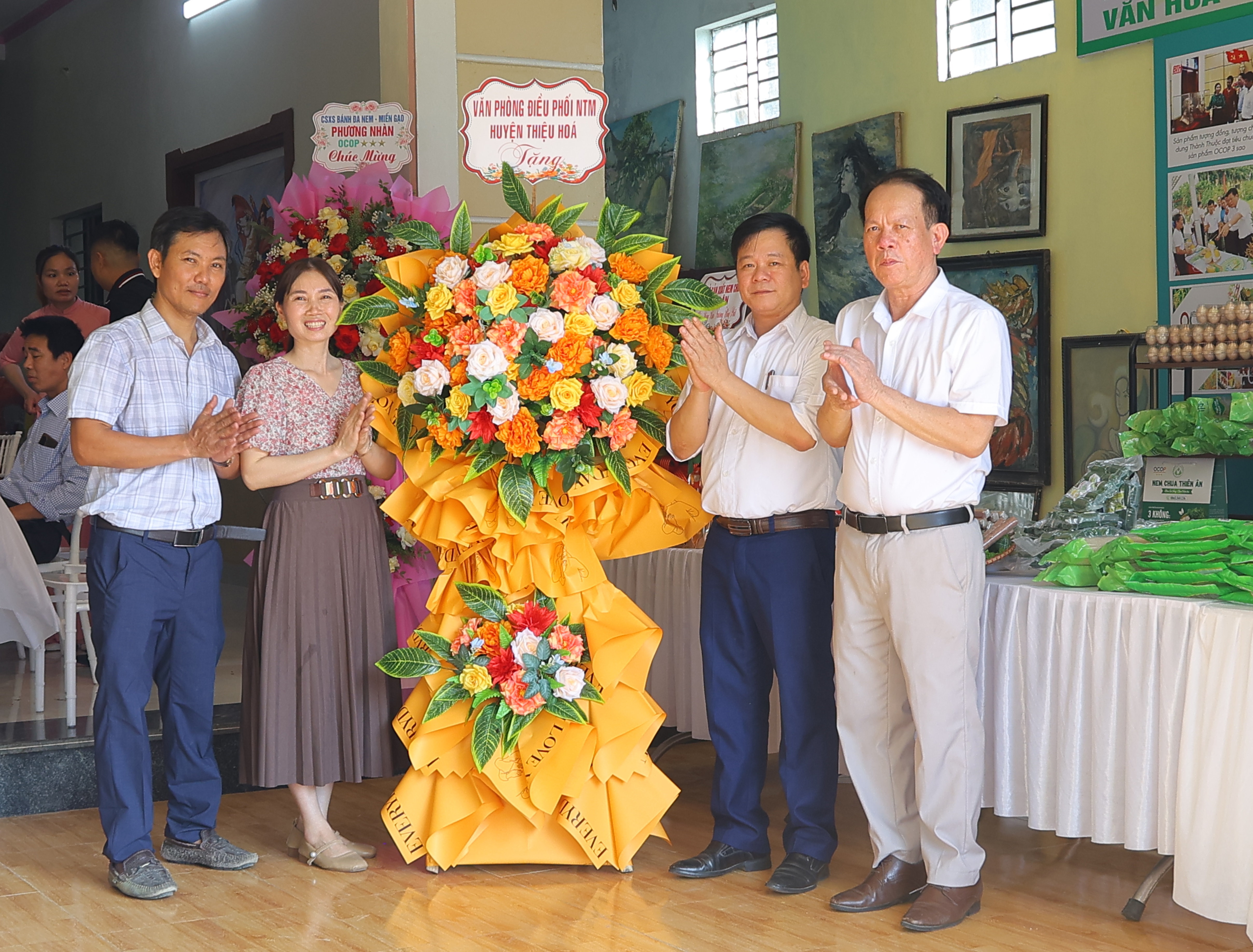 Đại diện văn phòng điều phối nông thôn mới huyện tặng hoa chúc mừng cửa hàng