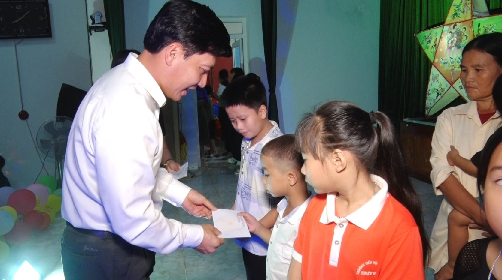 Bí thư Huyện ủy Nguyễn Văn Biện tặng quà cho các cháu thiếu nhi là con em của 28 hộ gia đình thủy cơ, các trẻ có hoàn cảnh đặc biệt khó khăn, trẻ khuyết tật, trẻ có thành tích cao trong học tập.
